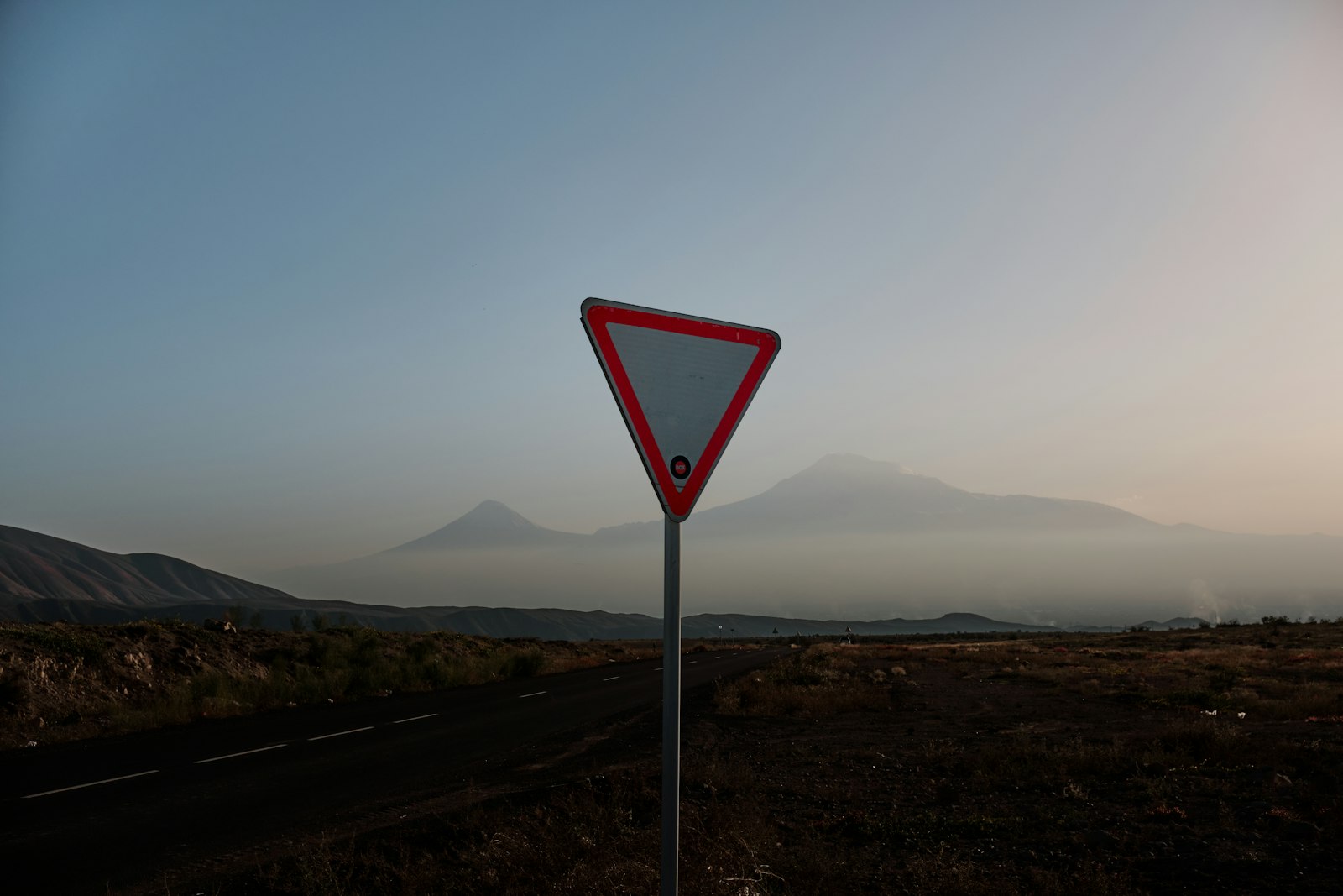 Dağların önünde yol kenarı levhası